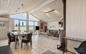 a dining room and living room with a table and chairs at Holiday Home Sivsangervænget Tarm in Hemmet