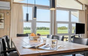 a dining room with a table and a large window at Holiday Home Sivsangervænget Tarm in Hemmet