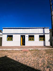 オウロ・プレットにあるRecanto do Sol - Lavras Novasの黄色い窓と黄色いドアのある白い家