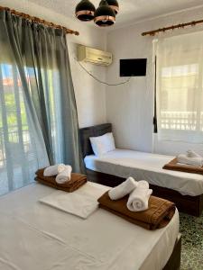 2 posti letto in camera con asciugamani di PELEKAN rooms and apartments ATHINA 23 a Pefkohori