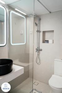 a bathroom with a glass shower with a toilet at Asteria Apartments in Animborió +47 photos