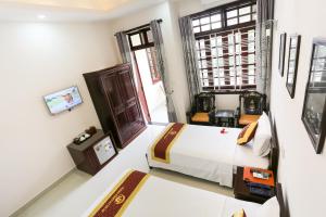 1 dormitorio con cama y ventana en Phoenix Homestay, en Hoi An