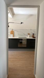 an open door into a kitchen with a counter at le prieuré in Vals-les-Bains +20 photos