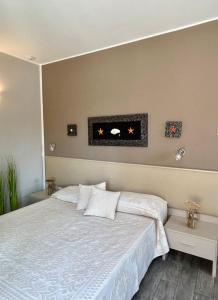 Un dormitorio con una cama con una colcha blanca. en La Locanda di Piazza, en Santa Teresa Gallura
