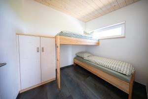 two bunk beds in a small room with a window at Ferienhaus am Flugplatz, umgeben von Natur in Kühndorf