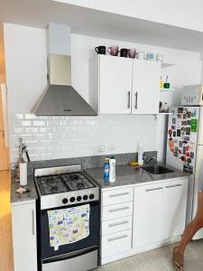 a kitchen with white cabinets and a stove top oven at Delta House in Tigre