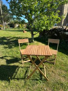 a picnic table and two chairs next to a tree at The Old Post Office B&B in Longwitton