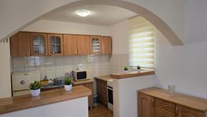 a kitchen with wooden cabinets and an archway at Vito Apartments Sutomore in Sutomore