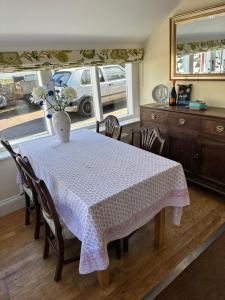 a dining room with a table with a vase on it at The Old Post Office B&B in Longwitton