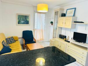 a living room with a couch and a television at Berria Beach and Pool in Santoña
