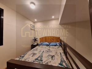 ein Schlafzimmer mit einem Bett mit einem Schild an der Wand in der Unterkunft Lucena Primeloft Townhome Transient in Lucena