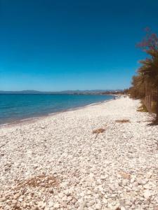 a white beach with rocks and the ocean at Barreira Beachfront Room 5 in Kalamata