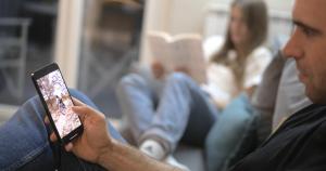 a man holding a tablet computer in front of a woman at Appartamento Melograno "A Casa Felice" in Pietra Ligure