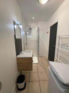 a white bathroom with a sink and a shower at Appart 2 à croix in Croix