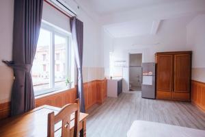 a kitchen with a table and a refrigerator and a window at Chapi Hotel in Xóm Ðé