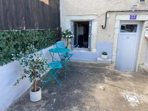 eine Terrasse mit Tisch und Stühlen neben einem Gebäude in der Unterkunft Studio Joseph 5 minutes Le Puy en Velay in Espaly-Saint-Marcel