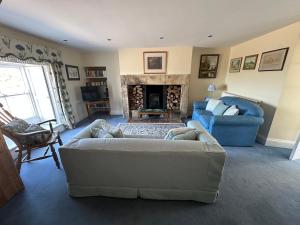 a living room with a couch and a fireplace at The Old Post Office B&B in Longwitton