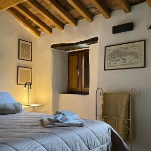 a bedroom with a bed and a table and a window at Ca' di Nieri The Saints' Lodge in Monte Santa Maria Tiberina