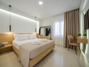 a bedroom with a bed and a desk and a chair at ELiXiR 3 Luxury apartments in Agios Nikolaos