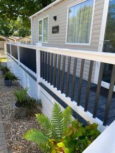 a fence on a house with plants on it at Coghurst Hall Holiday Home Sleeps 6, 2 bedrooms in Hastings