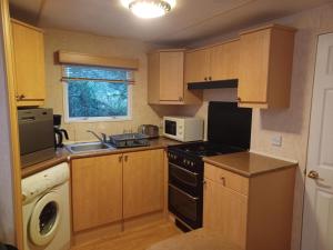 a small kitchen with a stove and a microwave at Etang de Peyrilhac in Peyrilhac