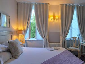 une chambre avec un lit blanc et une fenêtre dans l'établissement Hôtel Traiteur Les Ormes, The Originals Relais, à Barneville-Carteret