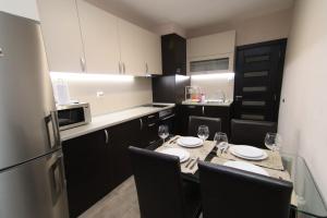 a kitchen with a table with chairs and a refrigerator at Parkzicht Gent in Ghent