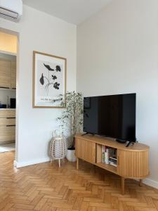 een woonkamer met een flatscreen-tv op een houten entertainmentcentrum bij RookieC Two Bedroom peaceful location old town AC in Cascais