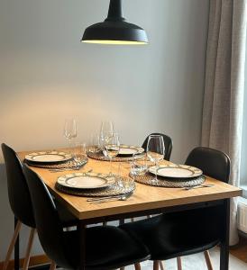 a wooden table with wine glasses and plates on it at One bedroom apartment in Rovaniemi +5 photos