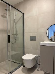 een badkamer met toilet en glazen douche bij RookieC Two Bedroom peaceful location old town AC in Cascais