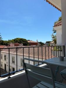 een balkon met een tafel en uitzicht op een gebouw bij RookieC Two Bedroom peaceful location old town AC in Cascais
