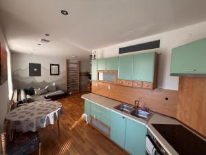 a kitchen with blue cabinets and a living room at apartmán minimal in Spišská Nová Ves