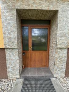 a wooden door of a building with a brick wall at apartmán minimal in Spišská Nová Ves