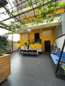a patio with tables and chairs and a yellow wall at Casa Shpresë - The Traditional Suite in Tirana