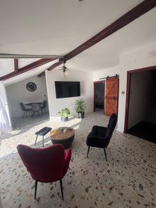 a living room with chairs and a table and a tv at Villa Cvetić in Selce