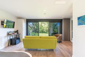 a living room with a yellow couch and a window at Waterfield House B&B in Dorchester