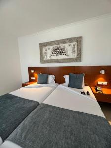 a hotel room with two beds and a picture on the wall at BE ONE HOTEL Caldas da Rainha - by MHMB Hospitality in Caldas da Rainha +37 photos