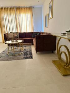 a living room with a couch and a table at High Rise Executive Luxurious Apartments Facing Centaurus Mall - LMY Islamabad in Islamabad