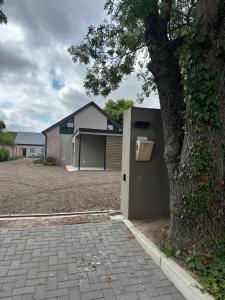 a house with a tree next to a building at Fallen Oak Villa 1 in George