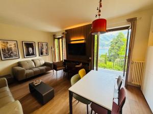 een woonkamer met een tafel en een bank bij Casa Giallo village home-by Italian Apartaments in Lenno