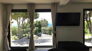 a living room with a large window with a television at Val Mar in Novi Vinodolski