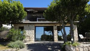 a stone house with large windows and a patio at Val Mar in Novi Vinodolski
