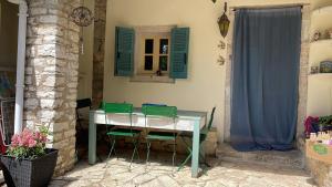 a table and chairs in a room with blue shutters at Tritzi house in Mesochórion