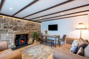 a living room with a stone fireplace and a table at Keel Cottage & Dog Friendly in Nairn