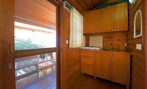 una cucina con armadi in legno, una finestra e una porta di Yeniliman Bungalov Evleri- Sümbül Adlı Ev -Karaburun -İzmir a Karaburun