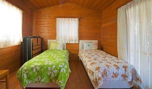 una camera con due letti in una baita di legno di Yeniliman Bungalov Evleri- Sümbül Adlı Ev -Karaburun -İzmir a Karaburun
