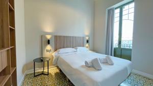 a bedroom with a large white bed with towels on it at Heritage apartamentos in Villajoyosa