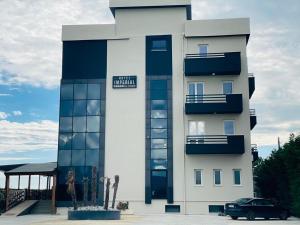 un edificio con un coche aparcado delante en Imperial Hotel, en Shënkoll