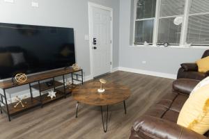a living room with a couch and a table at Pristine 3bdr 2ba Condo UChicago in Chicago