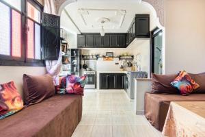 a living room with two brown couches and a kitchen at Marrakech apartment with city and Atlas Mountains view in Marrakech